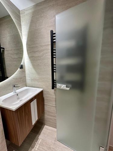 a bathroom with a sink and a mirror at Eleve Residences - Sand Studio in Sofia