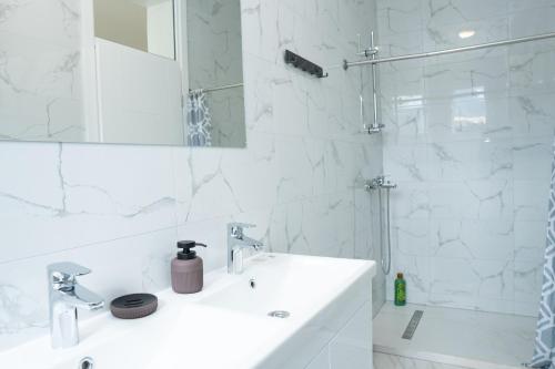 a white bathroom with a sink and a shower at Hotel Han Gusinje in Gusinje