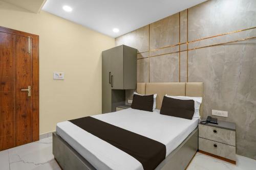 a bedroom with a bed and a wooden door at Super Hotel O RS PALACE in Jhānsi