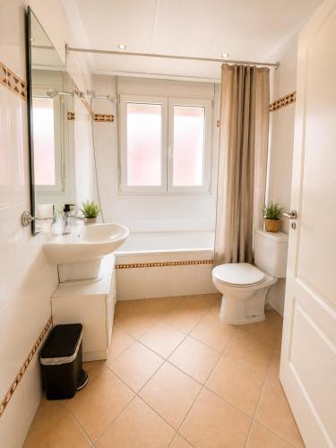 a bathroom with a sink and a toilet and a window at Casa Azul, with a shared pool in Baños y Mendigo