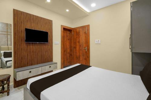 a bedroom with a bed and a flat screen tv at Super Hotel O RS PALACE in Jhānsi