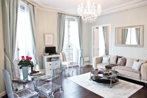 een woonkamer met een bank en een tafel bij La Charme Du Marais in Parijs
