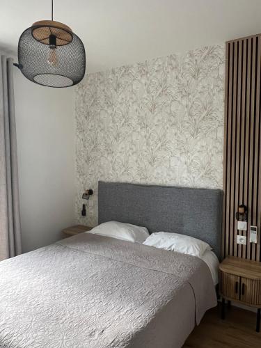 a bedroom with a large bed with a floral wallpaper at Les Paquebots - Hôtel & Restaurant in Port-Vendres