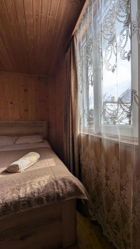 a small bedroom with a bed and a window at Guesthouse Marshan in Ushguli
