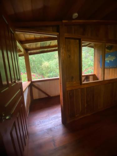 an open door of a room with a window at Hotel El Abrazo del Arbol in Mindo