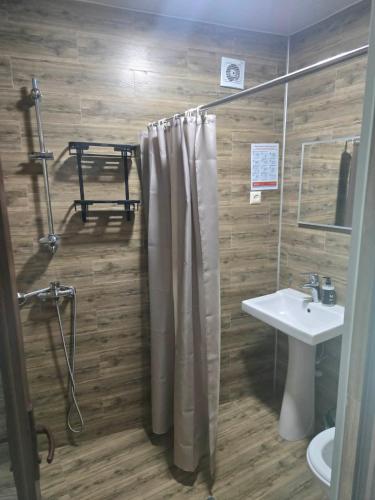 a bathroom with a shower curtain and a sink at Green House in Ureki