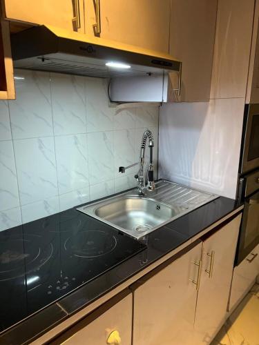 a kitchen with a sink and a black counter top at RÉSIDENCE IDM-Ngoma in Kinshasa
