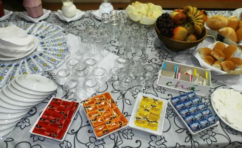 een tafel met borden en kommen met eten erop bij Icaropê Hotel in Concordia