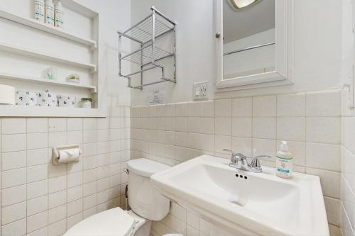a white bathroom with a toilet and a sink at Champ's Camp in Colchester