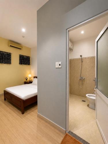 a bedroom with a bed and a shower and a toilet at Salyna Motel in Danang