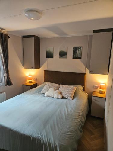 ein Schlafzimmer mit einem Bett, auf dem ein weißes Kissen liegt in der Unterkunft Roosje in Hoenderloo