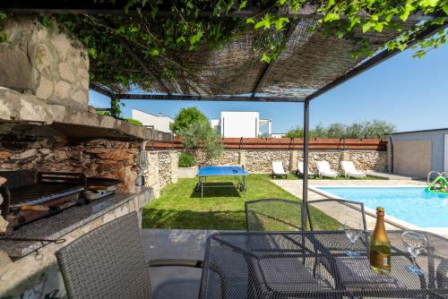 a patio with a table and a swimming pool at Holiday Home Casa Vida in Rakalj