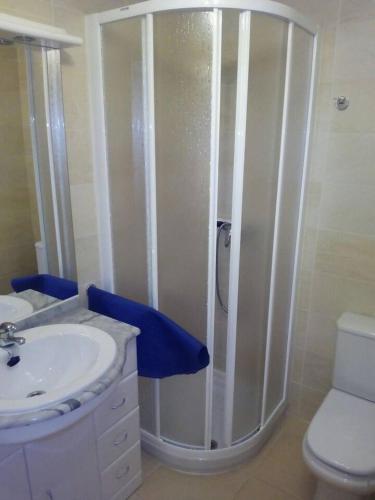 a bathroom with a shower and a sink and a toilet at Duplex Playa Rapadoira con piscina in Foz