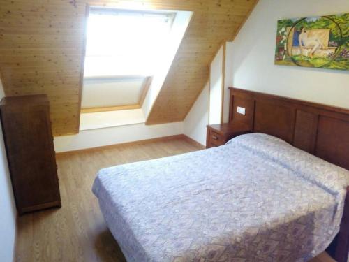 a small bedroom with a bed and a window at Duplex Playa Rapadoira con piscina in Foz