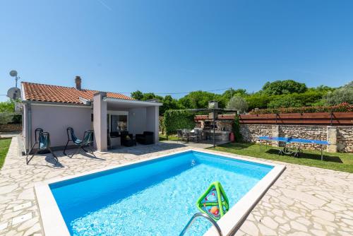 a swimming pool in a backyard with a house at Holiday Home Casa Vida in Rakalj