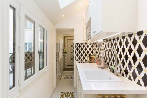 une salle de bain blanche avec un lavabo et une fenêtre dans l'établissement Le Diamant En Isle, à Paris