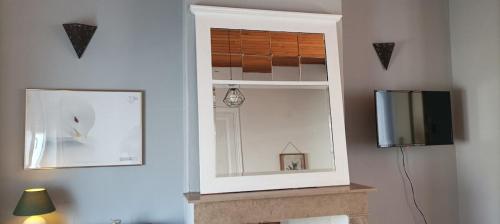 a mirror and a television in a room at Maison Aux Cailloux in Calais