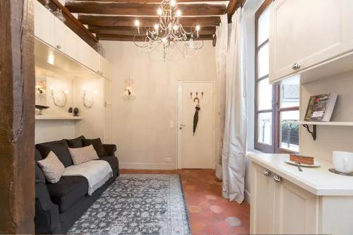 a living room with a couch and a chandelier at Le Diamant En Isle in Paris