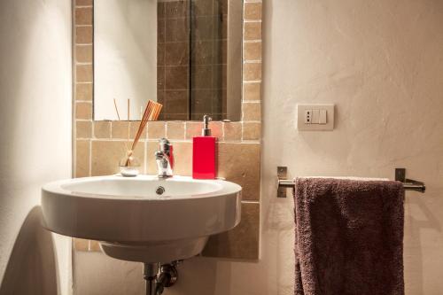 a bathroom with a white sink and a mirror at Da Leo in Montefollonico