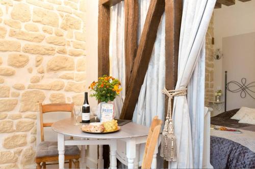 - une table avec une bouteille de vin et une assiette de fromage dans l'établissement Le Diamant En Isle, à Paris