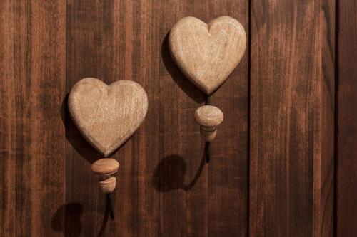 three wooden hearts on a wooden wall at Da Leo in Montefollonico