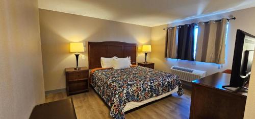 a hotel room with a bed and two lamps at Farwest Motel in Everett