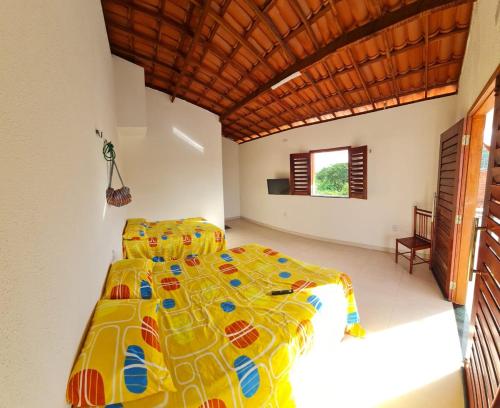 a bedroom with a bed with a colorful comforter at Casapraiatracuá in Beberibe
