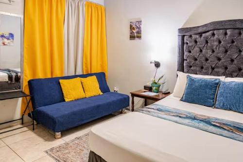 a bedroom with a bed and a blue chair at Mona Master suite in Kingston