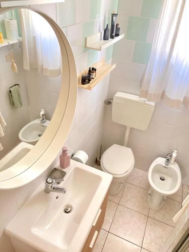 a bathroom with a sink and a toilet and a mirror at Cozy Vallevò in Rocca San Giovanni