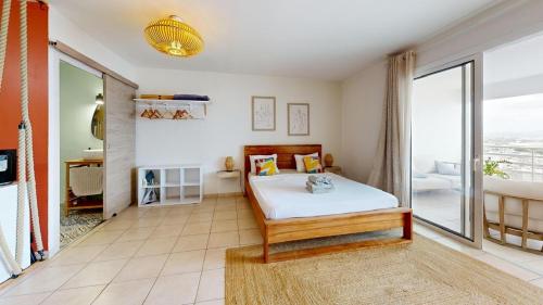 a bedroom with a bed and a large window at Bella Apartment in Fort-de-France