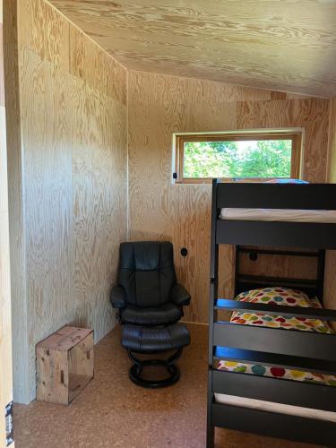 a bedroom with a chair and a bunk bed at The forest in Sjöbo