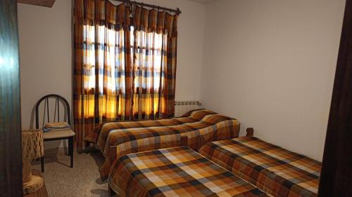 a room with three beds and a window at la casona de yala in Yala