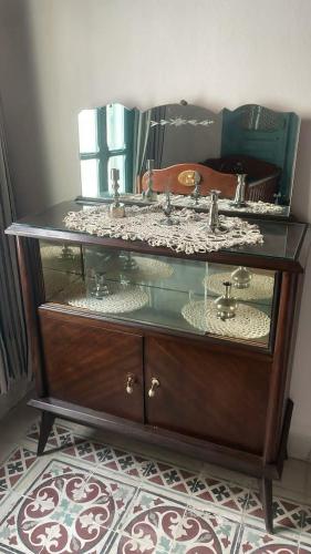 a glass cabinet with a sink and a mirror at Beit Emna3 in Kairouan