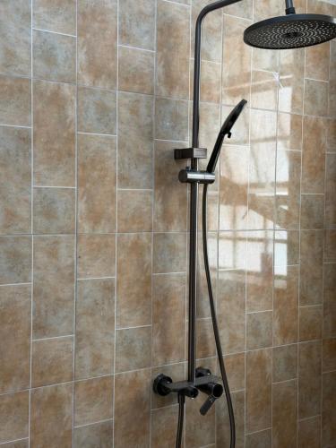a shower with a shower head in a bathroom at Bubuli country club in Lyamutundwe