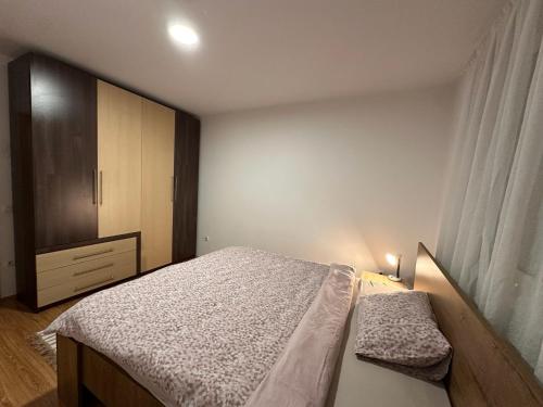 a small bedroom with a bed and a dresser at Boulevard Mitrovica in Mitrovica