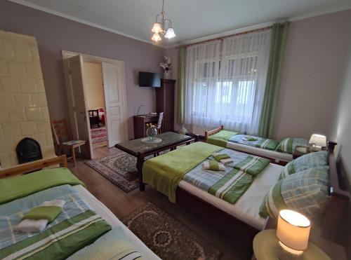 a room with two beds and a table in it at Vazsita ház in Erdőbénye