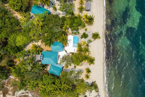 an overhead view of a beach with blue resorts at Picture-Perfect 2-Bedroom Oceanfront Home w Pool in Placencia