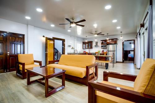 a living room with a couch and a table at Elegant Beachfront Villa Pool & Beach Family Fun in Maya Beach