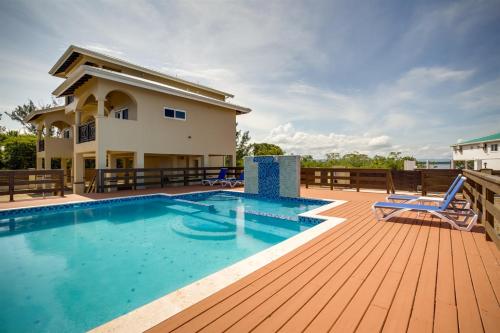 a swimming pool on a deck with a house at Elegant Beachfront Villa Pool & Beach Family Fun in Maya Beach