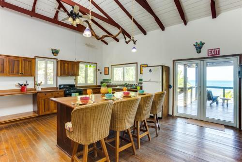 a kitchen with a large wooden table and chairs at Spacious Beachfront Family Home w Caribbean Views in Maya Beach