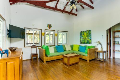 a living room with green and blue couches at Spacious Beachfront Family Home w Caribbean Views in Maya Beach