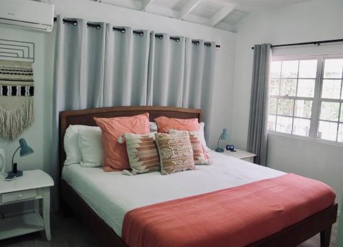 a bedroom with a bed with pillows and a window at Beachfront Bungalow-Pool & Oceanfront-Views-Golf in Seine Bight Village