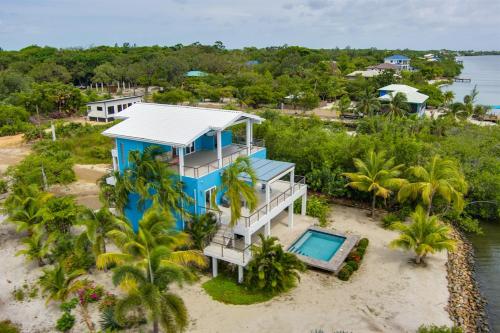 an aerial view of a blue house on the beach at Grand Sunset Decks Luxury Home on the Lagoon in Maya Beach