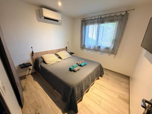 a bedroom with a bed with two stuffed animals on it at Chez Fred et Marie in Figari
