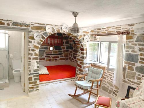 a room with a bed in a brick wall at Seafront House, Private Beach, Sunset View, Diliso in Vathírrevma