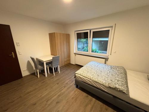 a bedroom with a bed and a desk and a table at Cozy Room Echterdingen Stuttgart Airport & Messe in Leinfelden-Echterdingen