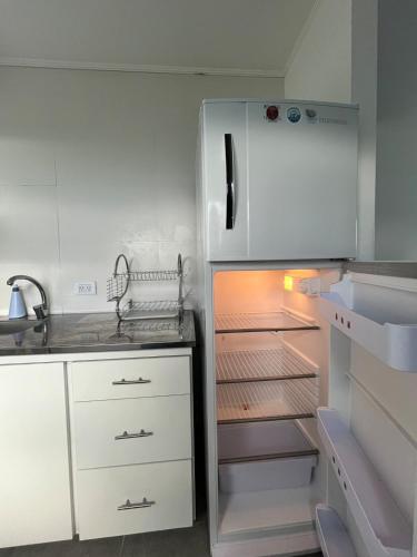 a white refrigerator with its door open in a kitchen at Refugios del Parque in Necochea