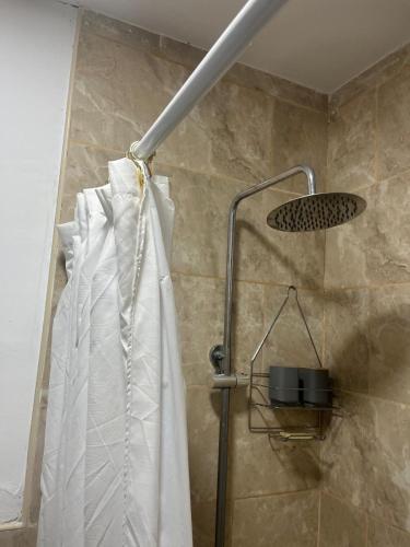 a shower with a white shower curtain in a bathroom at Refugios del Parque in Necochea