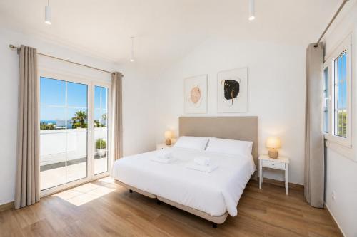 a bedroom with a white bed and a large window at Villa Yaiza Secret 3 in Yaiza