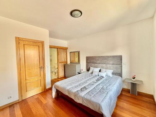 a bedroom with a large bed and a wooden floor at NCHouse in Esposende